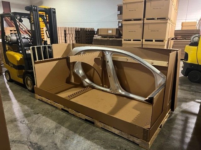 Corrugated container holding an automotive door frame